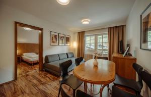 salon z kanapą i stołem w obiekcie TheResi Appartements w Saalbach Hinterglemm