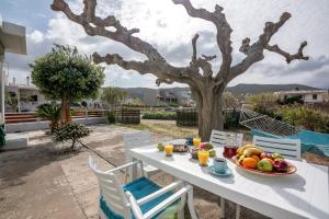 a table with a bowl of fruit and a tree at Lahardi - Seaside House in Kissamos