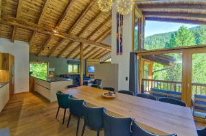 cocina y comedor con mesa de madera grande y sillas en Chalet Schmitten - by Alpen Apartments en Zell am See