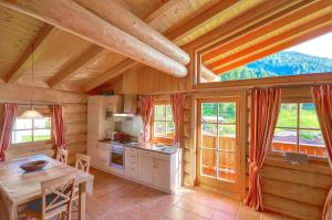 a kitchen with a table in a wooden house at Chalet Stabler - by Alpen Apartments in Zell am See