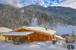 a log cabin with snow on the roof at Chalet Stabler - by Alpen Apartments in Zell am See