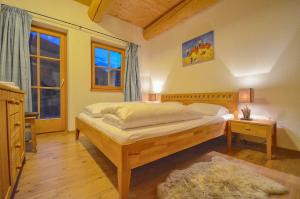 a bedroom with a large bed and a window at Chalet Stabler - by Alpen Apartments in Zell am See