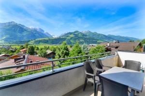 balcón con mesa, sillas y montañas en Panoramic View - by Alpen Apartments, en Piesendorf