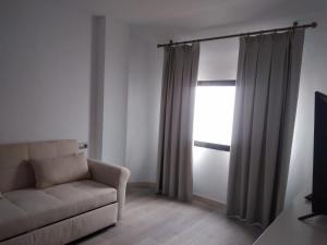 a living room with a couch and a window at Canaan Boutique Hotel Ronda in Ronda