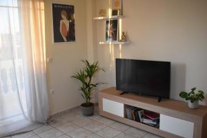 a living room with a flat screen tv on a stand at Kallias House in Kremasti