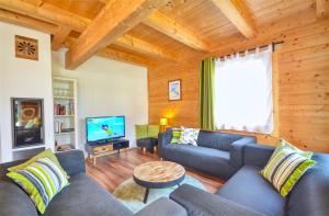 a living room with a couch and a tv at Chalet Seven - by Alpen Apartments in Zell am See