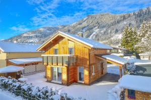 a log cabin in the snow with a mountain at Chalet Seven - by Alpen Apartments in Zell am See