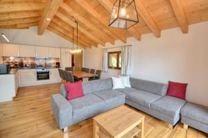 Ski-in Ski-out Chalet Maiskogel 13A - by Alpen Apartments في كابرون: غرفة معيشة مع أريكة وطاولة