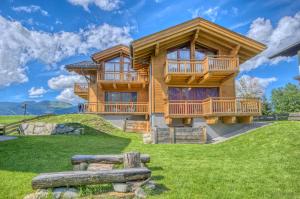 a log home with a large deck on a hill at Ski-in Ski-out Chalet Maiskogel 13B - by Alpen Apartments in Kaprun