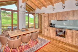 a kitchen and dining room with a table and chairs at Ski-in Ski-out Chalet Maiskogel 13B - by Alpen Apartments in Kaprun