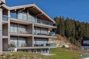 ホラースバッハ・イム・ピンツガウにあるApartment Berg & Tal - by Alpen Apartmentsの木立の丘の上の建物