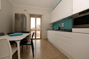 een keuken met witte kasten en een tafel met stoelen bij Il Faro - Pineto Vacanza in Pineto