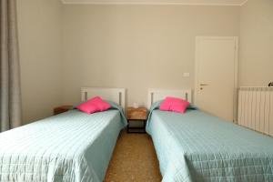 ピネートにあるIl Faro - Pineto Vacanzaのピンクの枕が備わる客室内のベッド2台