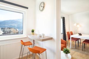 jadalnia z pomarańczowymi krzesłami i stołem w obiekcie Mozart Top 2 - by Alpen Apartments w mieście Zell am See