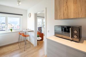 kuchnia z kuchenką mikrofalową, stołem i krzesłami w obiekcie Mozart Top 2 - by Alpen Apartments w mieście Zell am See