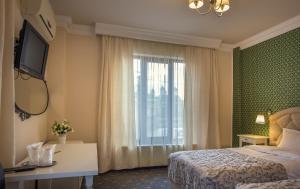 a hotel room with a bed and a window at Hotel Eden in Iaşi