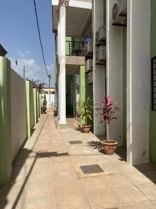 an empty hallway with potted plants on a building at Janneya Apartments in Sukuta