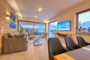 a living room with a couch and a tv at Gletscherblick 1 - by Alpen Apartments in Zell am See