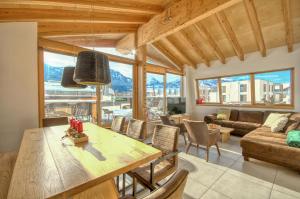 a kitchen and living room with a table and chairs at Gletscherblick 2 - by Alpen Apartments in Zell am See