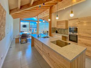 a kitchen with wooden cabinets and a large island at Gletscherblick 2 - by Alpen Apartments in Zell am See