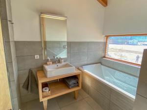 a bathroom with a sink and a bath tub at Gletscherblick 2 - by Alpen Apartments in Zell am See