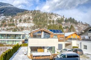 une maison avec une montagne en arrière-plan dans l'établissement Gletscherblick 2 - by Alpen Apartments, à Zell am See