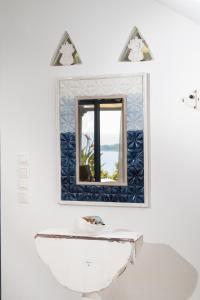 a bathroom with a sink and a mirror at Wonderful maisonette overlooking the Aegean Sea in Petriaí