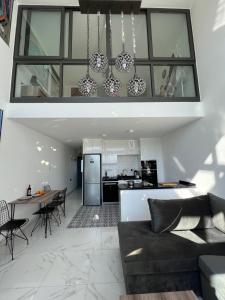 a living room and kitchen with a couch and a table at Hermes Penthouse Sea Sky & Mountains in Akanthou