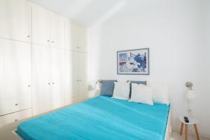 a bedroom with a blue bed with white cabinets at Wonderful maisonette overlooking the Aegean Sea in Petriaí
