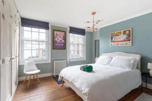 una camera con un letto bianco e due finestre di Stunning Townhouse with large roof terrace a Londra