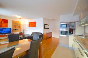 a kitchen and living room with a table and chairs at Apartment Leon - by Alpen Apartments in Zell am See