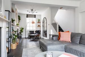 a living room with a couch and a chair at Stunning Townhouse with large roof terrace in London