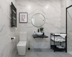 a bathroom with a toilet and a sink and a mirror at KAIXO BILBAO APARTMENTS in Bilbao