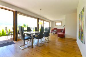 a living room with a dining room table and chairs at Sonnenhaus A - by Alpen Apartments in Zell am See