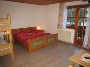 ツェル・アム・ゼーにあるSki-in Ski-out Chalet Kriekels - by Alpen Apartmentsのベッドルーム1室(赤いシーツ付きのベッド1台、窓付)