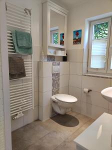 a white bathroom with a toilet and a sink at Pier 12 Ferienwohnung in Eckernförde