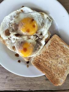 a fried egg and a slice of bread on a plate at Baan Hotelier Resort in Trat