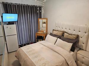 a bedroom with a bed and a television in it at RJs Guesthouse in Durban