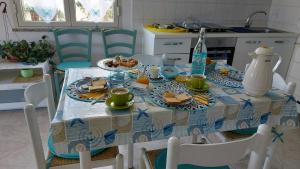 una mesa con un mantel azul y blanco con comida. en I Girasoli, en Tortolì