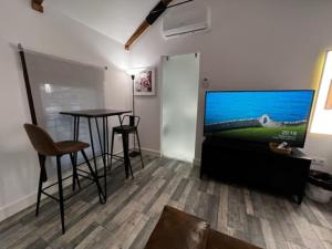 ein Wohnzimmer mit einem Tisch und einem Flachbild-TV in der Unterkunft 2A-Precioso Apartamento en pleno centro. A estreno in Alcázar de San Juan