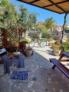 un patio con mesa, sillas y bicicleta en I Girasoli, en Tortolì