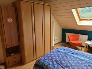 a bedroom with a bed and a cabinet and a window at Fewo-Minheim Waltraud und Franz Bayer in Minheim