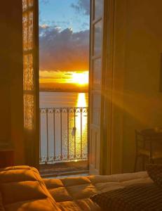 a room with a window with a view of a sunset at Camere A’ Marina in Siracusa