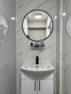 a white bathroom with a sink and a mirror at Wolf Inn Serviced Accommodation in Lowestoft