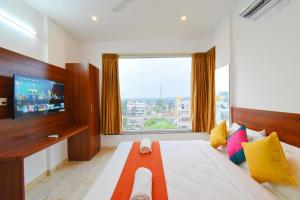 a bedroom with a large bed with a large window at Keerthis Royal Suites Kempegowda International Airport in Yelahanka