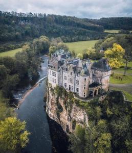 een kasteel op een klif over een rivier bij Maison familiale à Dinant in Dinant