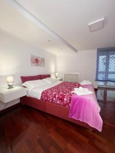 una camera da letto con un grande letto con una coperta rosa di Casa Vacanze Maridy a Napoli