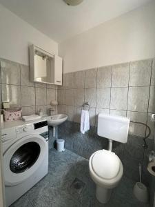 Apartman Kalinić في ستون: حمام مع غسالة ومرحاض