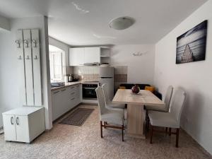 a kitchen with a table and chairs in a kitchen at Apartman Kalinić in Ston