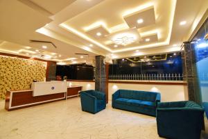 una hall con due sedie blu e una reception di Keerthis Royal Suites Kempegowda International Airport a Yelahanka